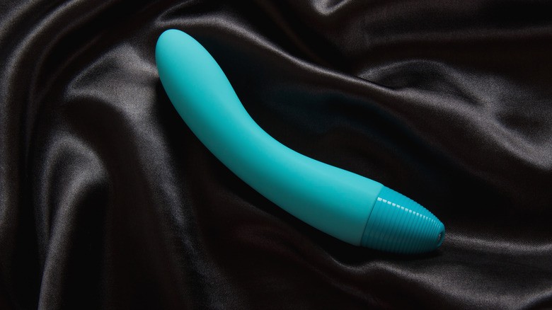 Vibrator albastru pe cearsafuri de matase neagra